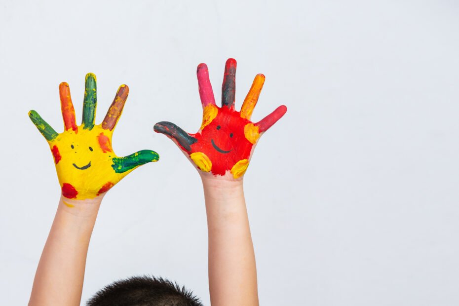 duas mãos pintadas com carinhas felizes - espectro autista